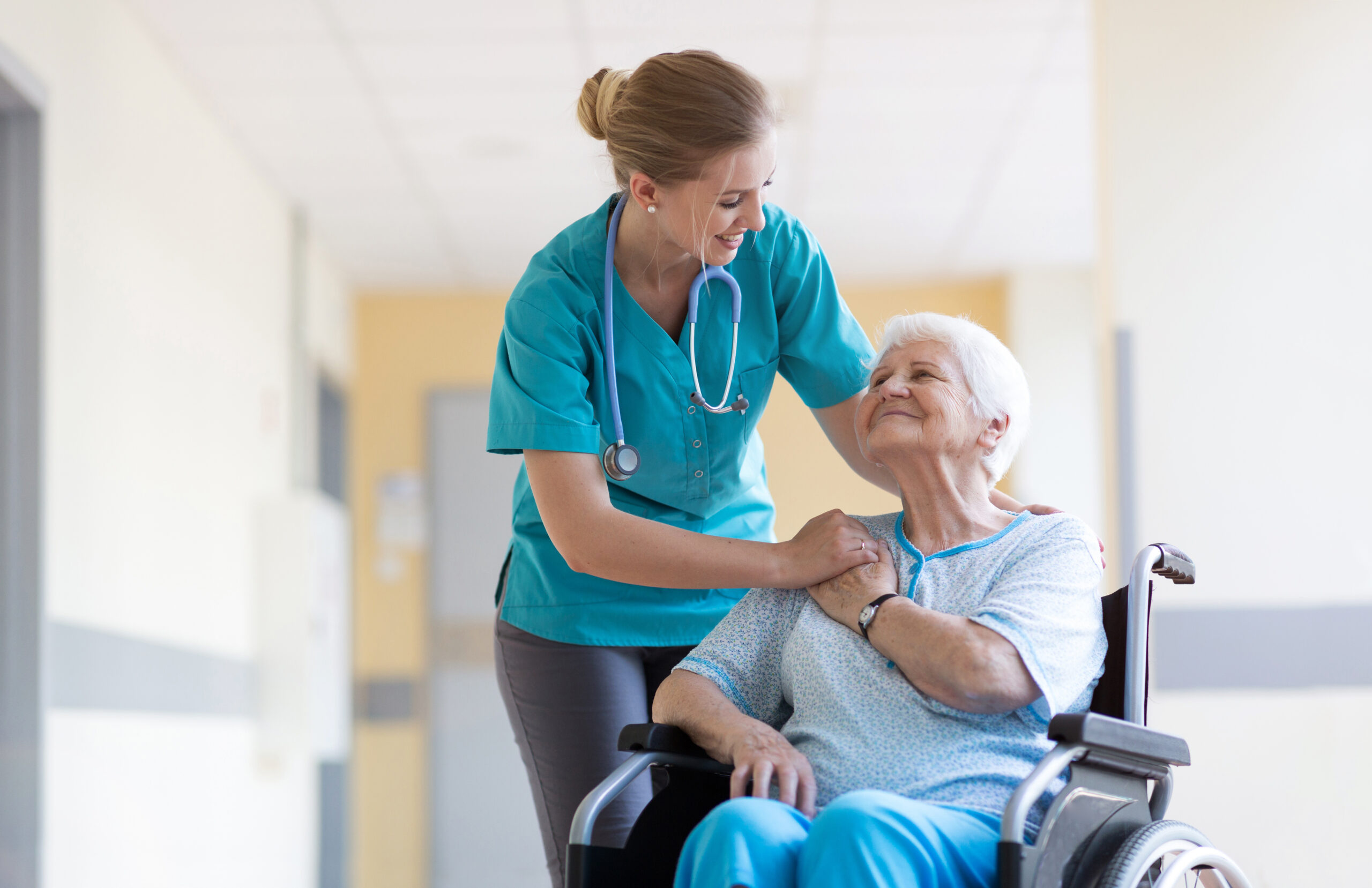 a Registered Nurse speaks with a senior citizen in a wheelchair