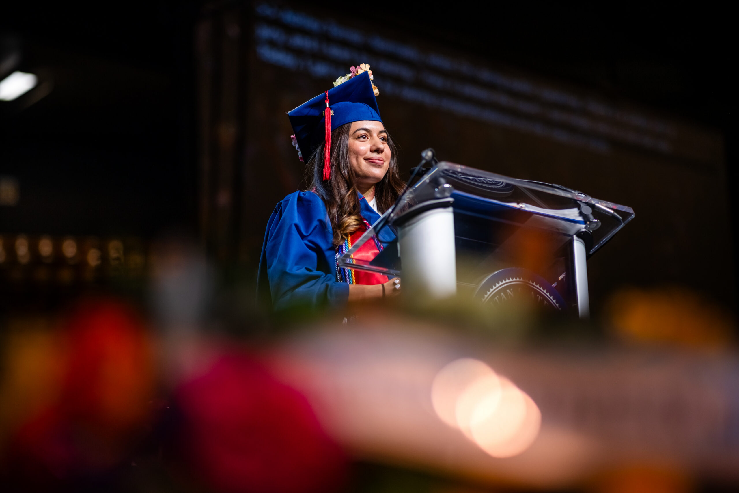 Ashely Torrez stand at the commencement podium and addresses the audience.