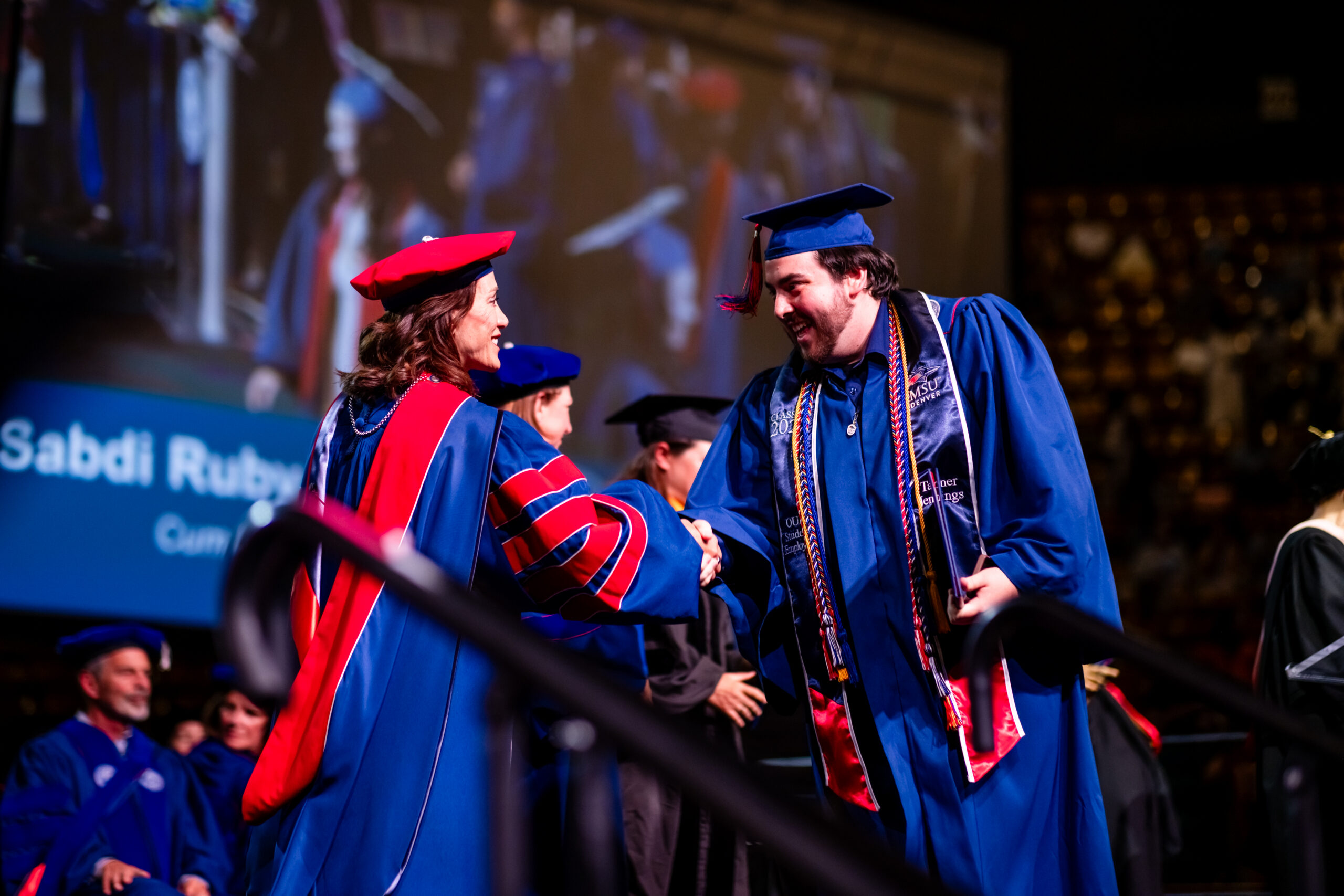 A graduate shakes hands with President Davidson on stage at Commencement