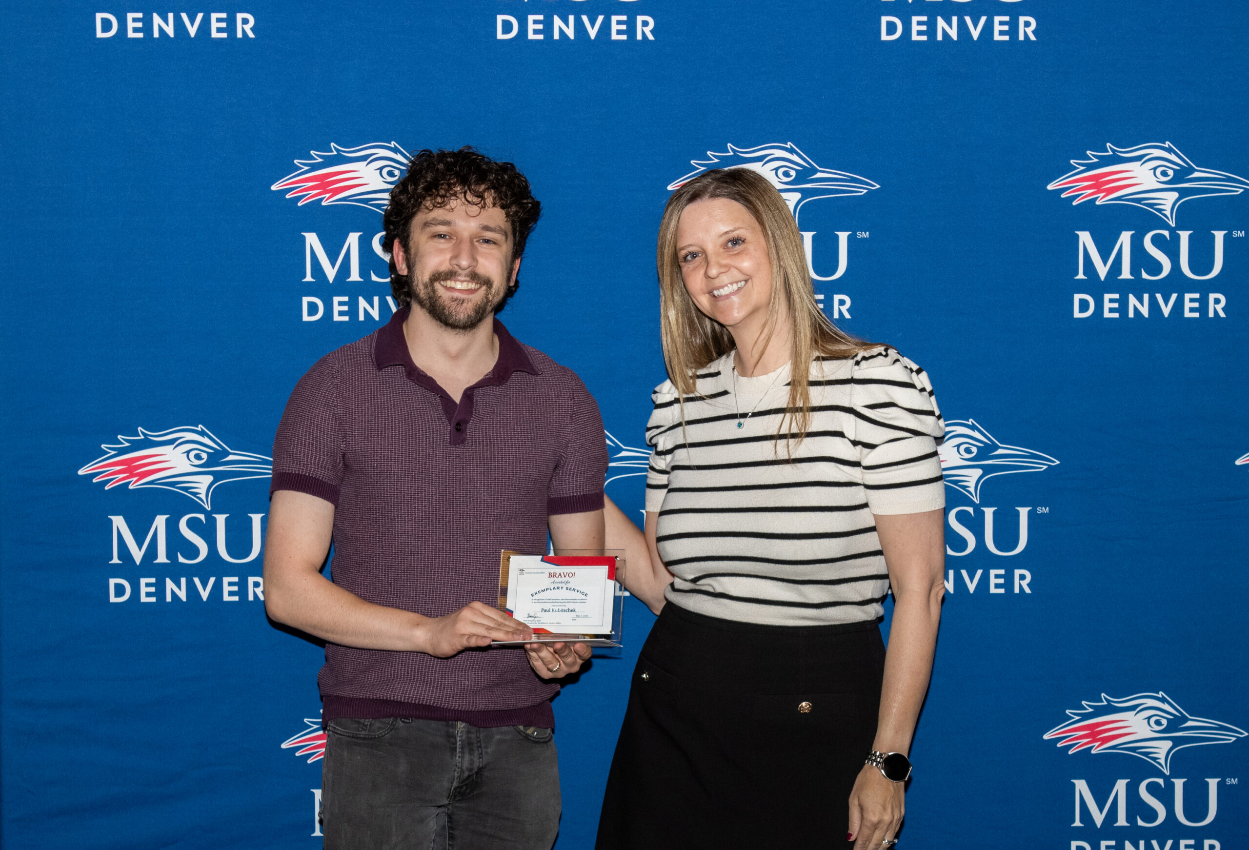 A photo of award winner with their award.