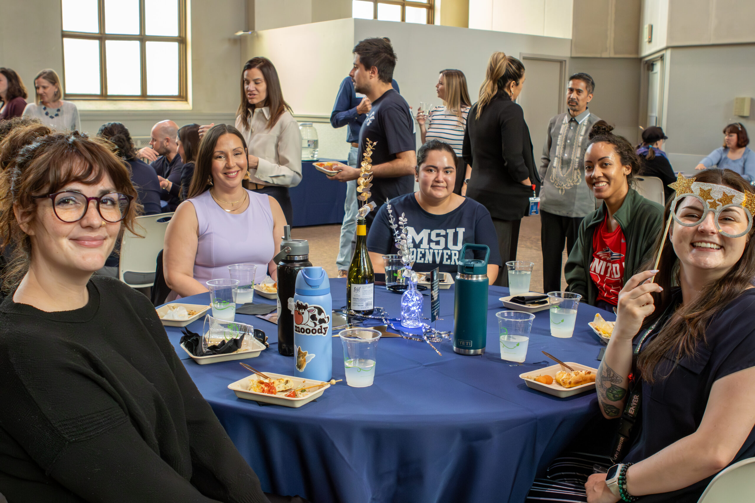 MSU Denver employees sitting around a table smiling at the camera.