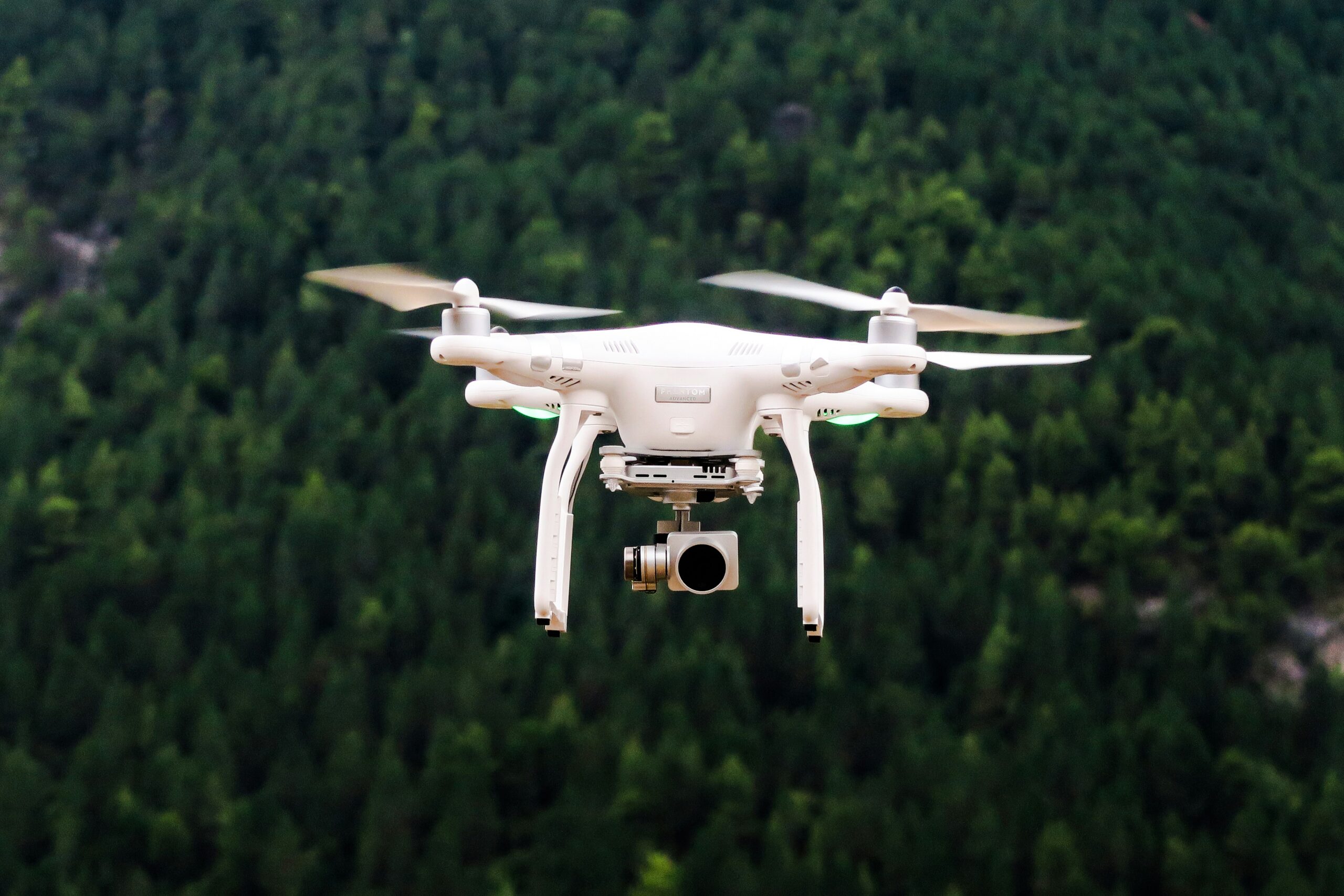 Drone flying in the air in front of trees
