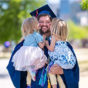 Graduate Chad Whitmer with his daughters at the specialty graduation celebration for parenting students.