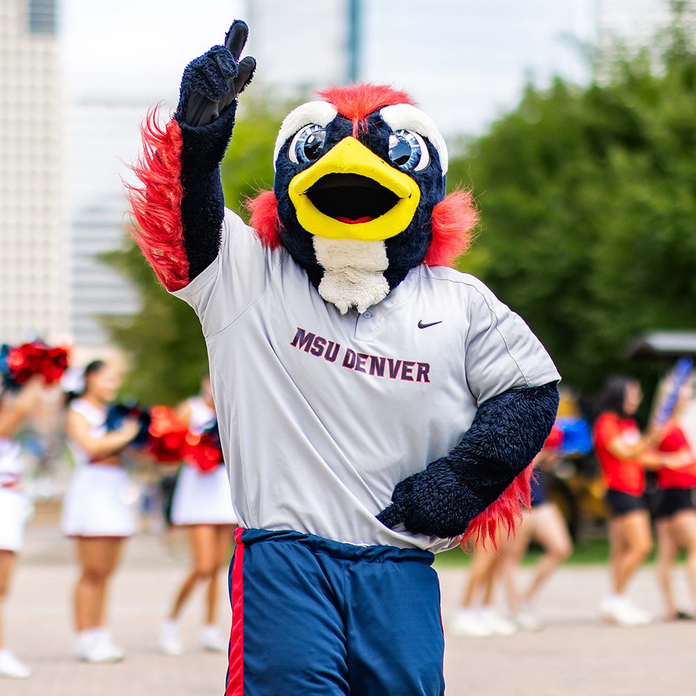 MSU Denver mascor Rowdy Roadrunner on campus pointing up