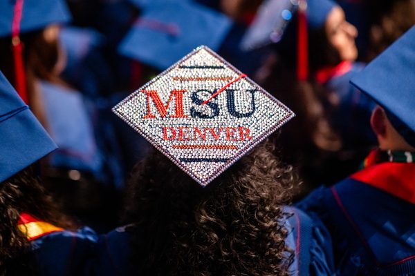The back of a graduate cap (mortarboard) with an intricate rhinestone design, which says MSU Denver in red and blue, with silver surrounding it
