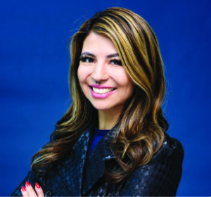 Woman with long hair in front of a blue background.