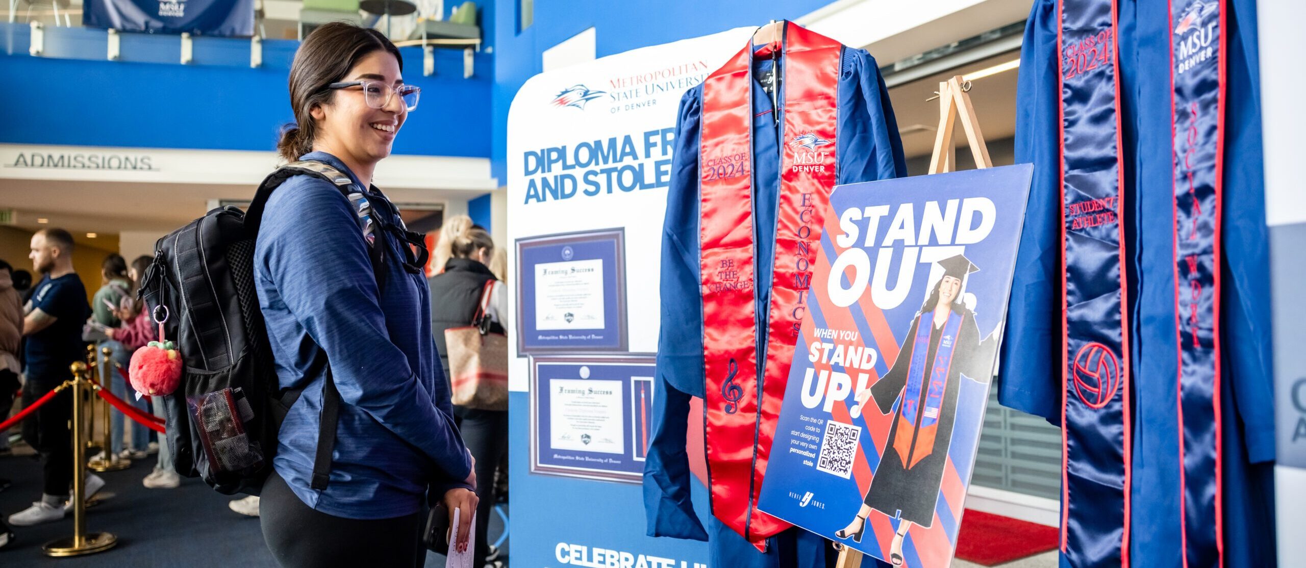 A student checks out a regalia set in the Jordan Student Success Building during the Commencement Expo.