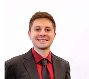 Man wearing a black suit jacket, red shirt and dark tie