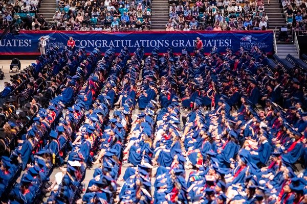 A wide angle is used to capture an aerial photo of the rows of seated graduates at Commencement