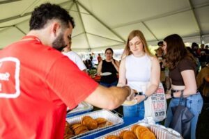 Staff member serving pancakes under the big tent