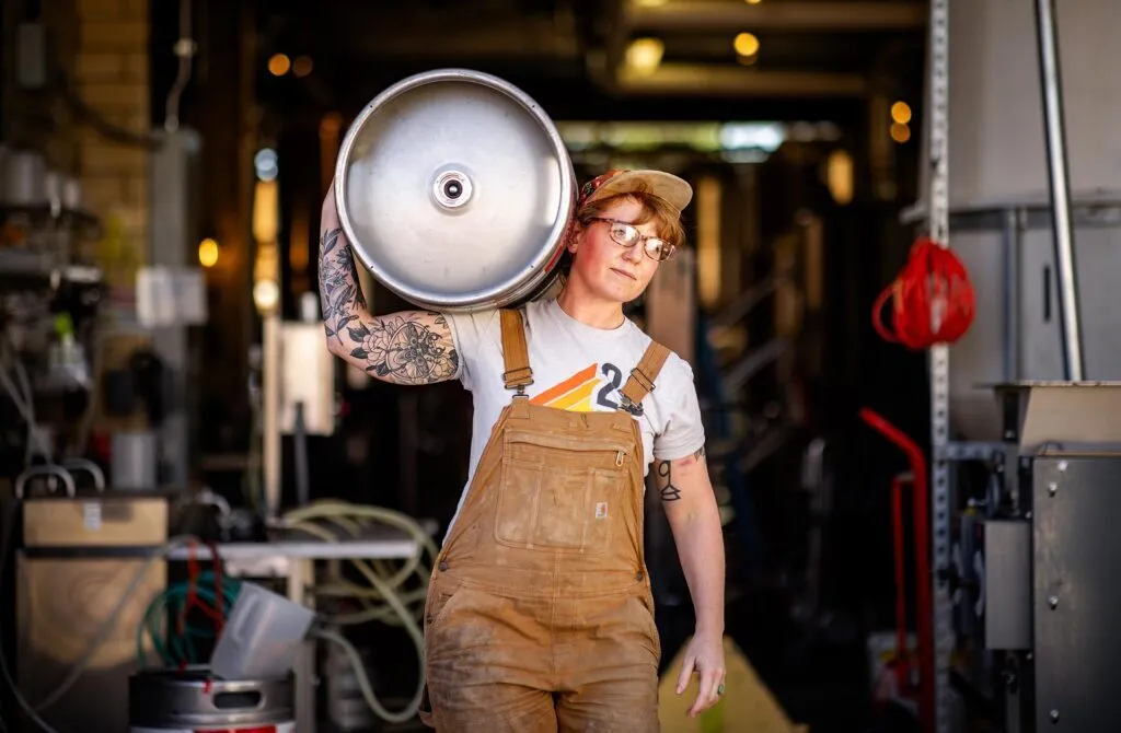 MSU Denver’s Leigh Nelson, lead brewer at Station 26, carries a keg on Sept. 22, 2023. Photo by Alyson McClaran