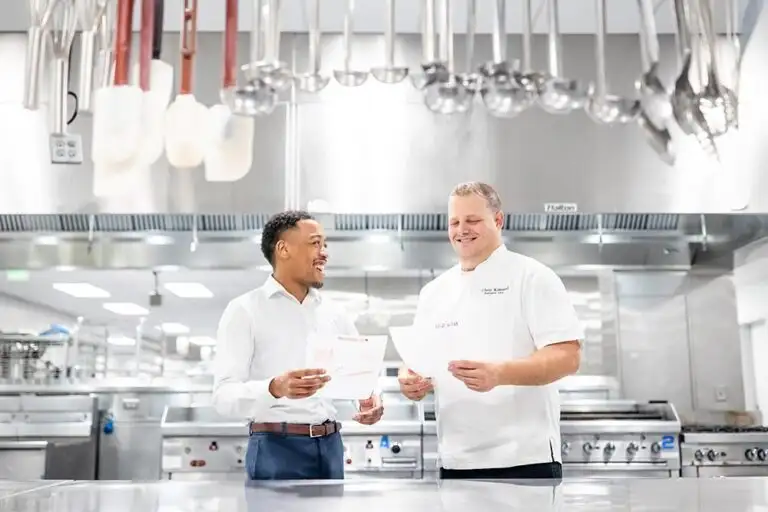 MSU Denver Hospitality student Tyrin Register, catering sales coordinator at the Colorado Convention Center, discusses event plans with Executive Chef Chris Kinsaul. Photo by Alyson McClaran