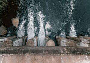 Arial view of water rushing out of a concrete pillar.