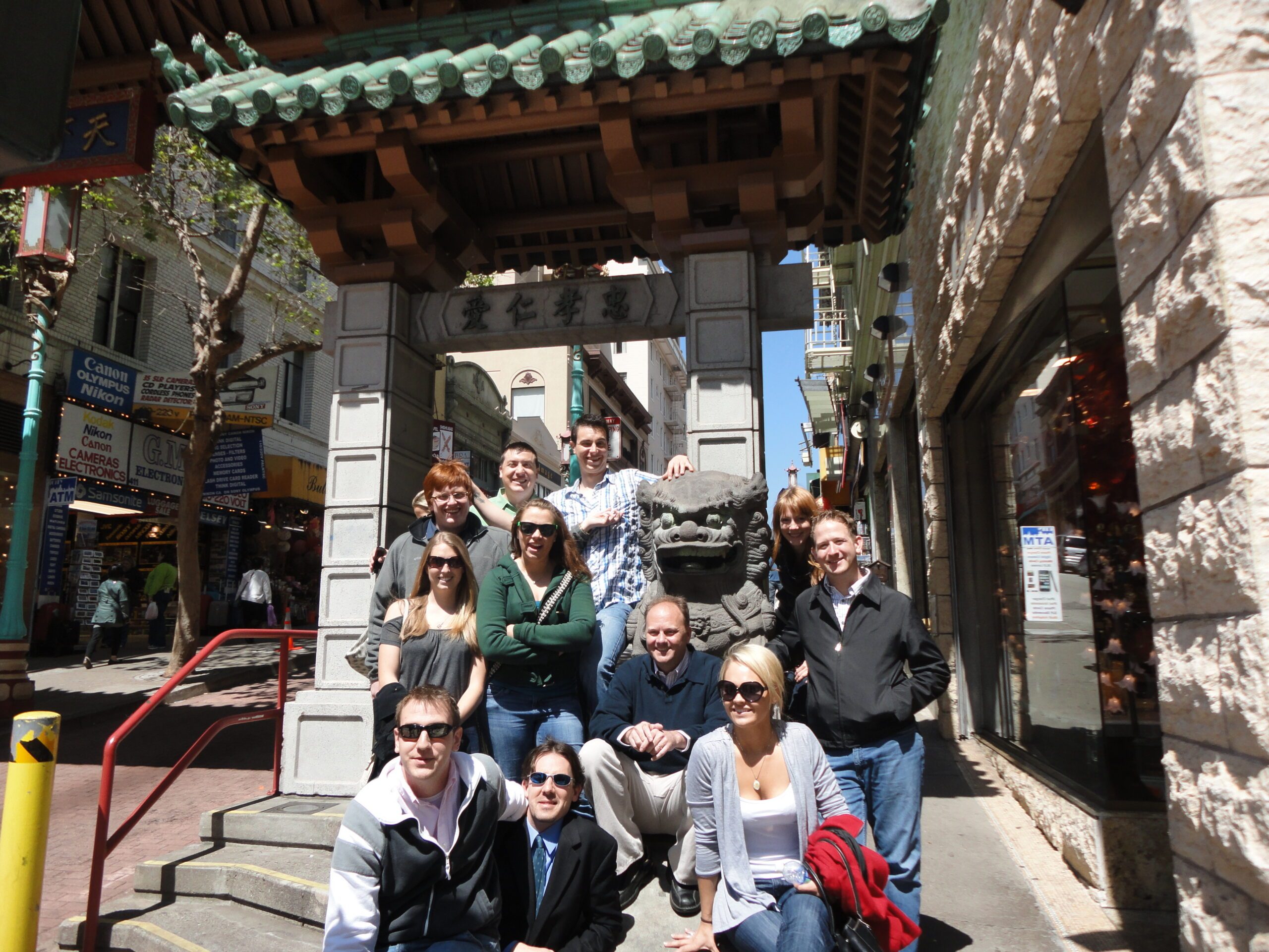 Richard Moeller and a group of Model UN students in 2011, posing beside a stone lion statue beneath a gate inscribed with the Chinese characters 忠孝仁愛.