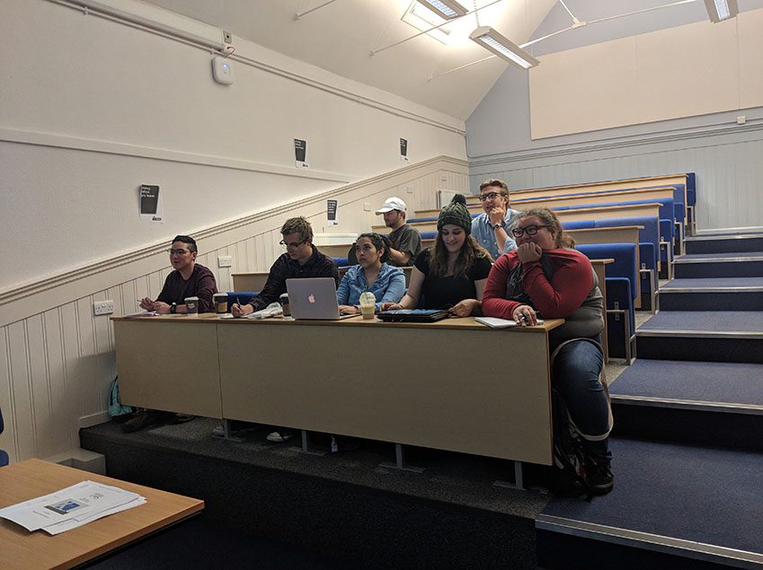 Seven Model UN students in 2018, seated in the front rows of a tiered lecture hall.