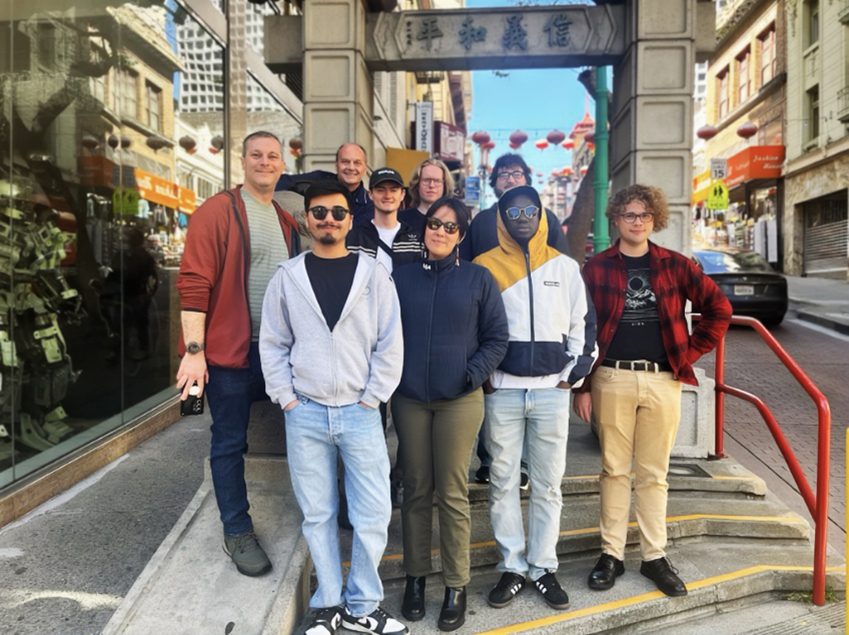 Richard Moeller and a group of Model UN students in 2025, posing on steps beneath a gate inscribed with the Chinese characters 信義和平.