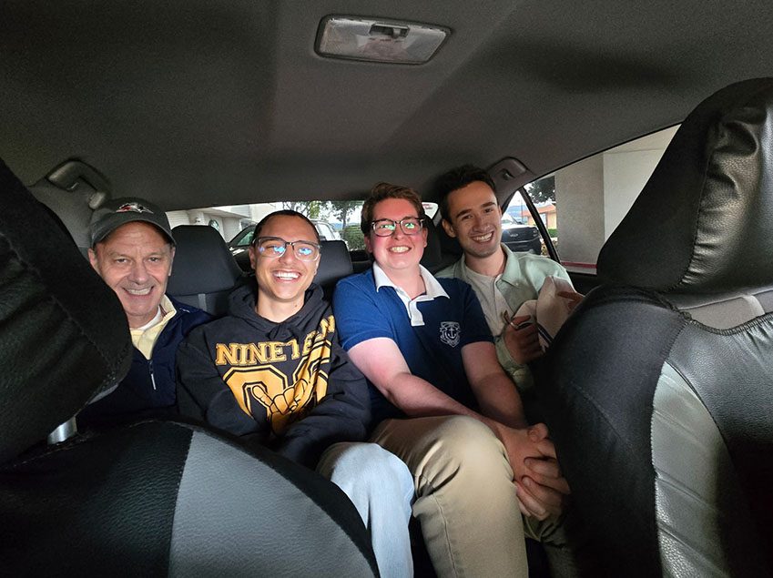 Richard Moeller and three Model UN students in 2026, smiling from the back seat of a car.