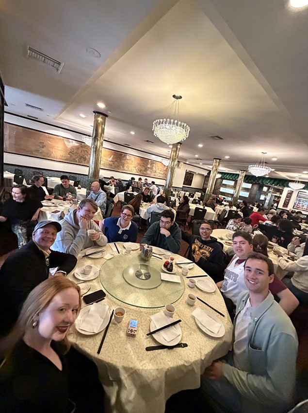 Richard Moeller and seven Model UN students in 2026, seated around a round table in a Chinese banquet restaurant.